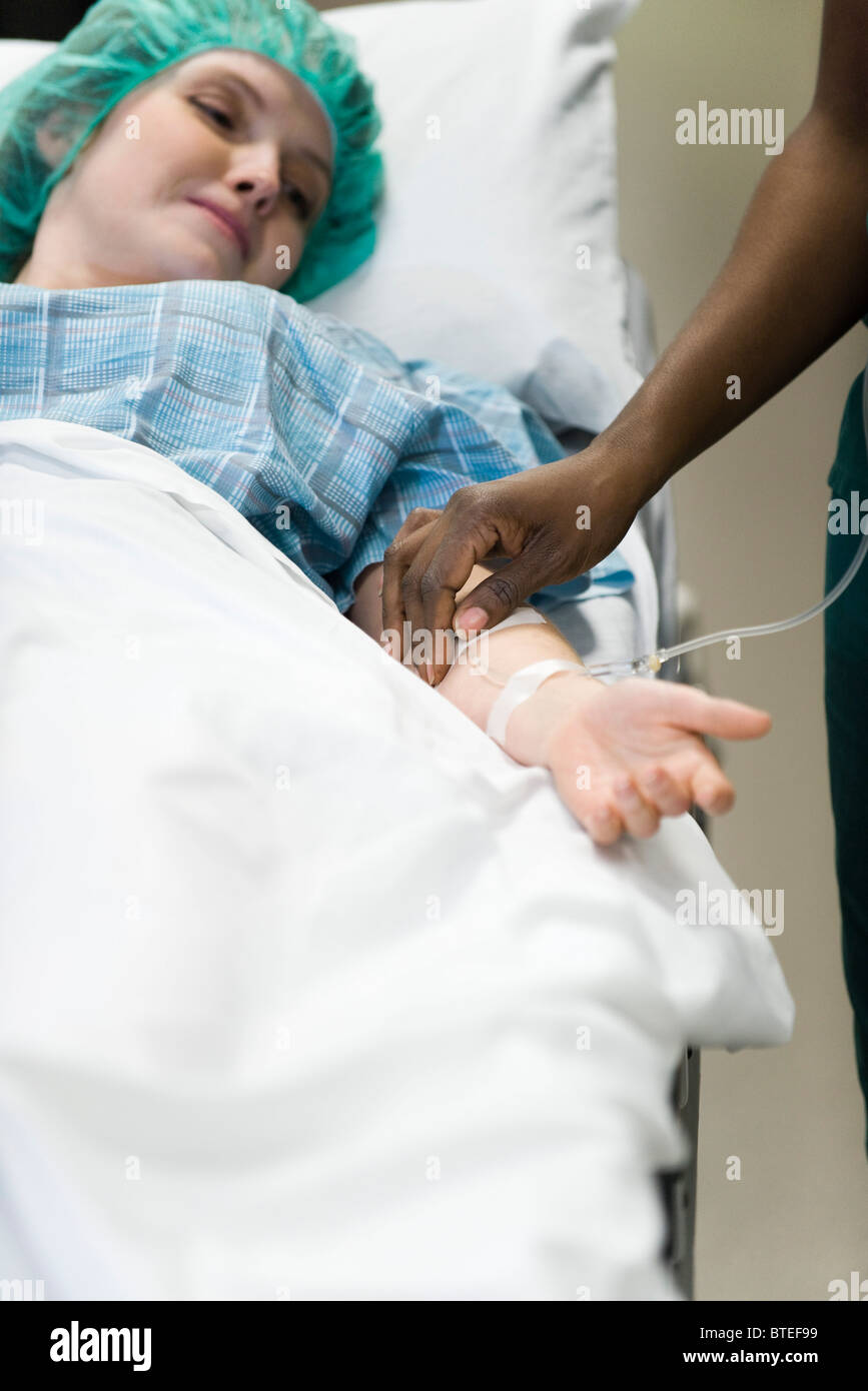 Paziente a guardare come controlli infermiere IV posizionamento ago nel braccio Foto Stock
