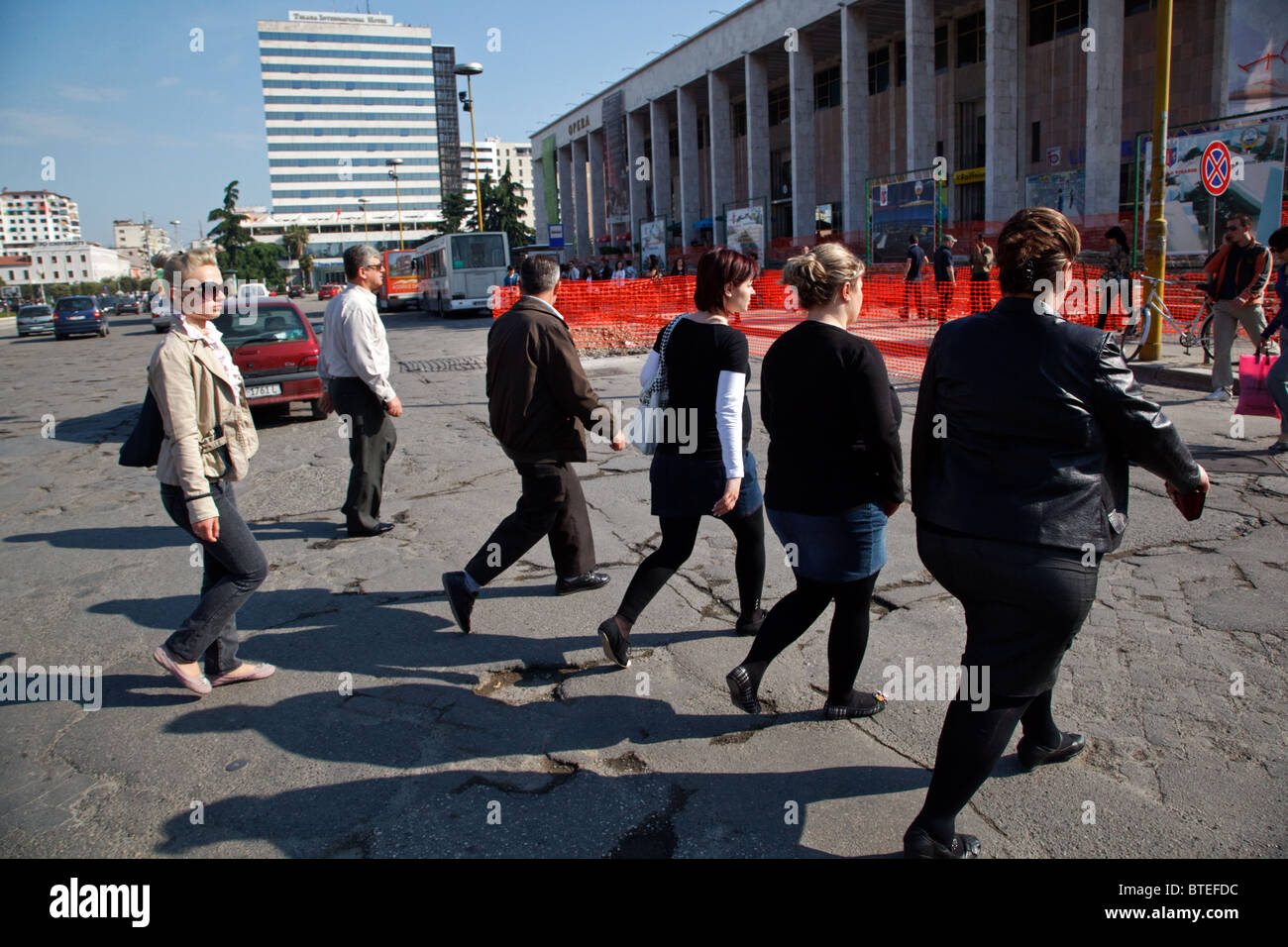 I giovani vanno a lavorare al mattino presso la Piazza Skanderbeg a Tirana, la capitale dell'Albania. Foto Stock