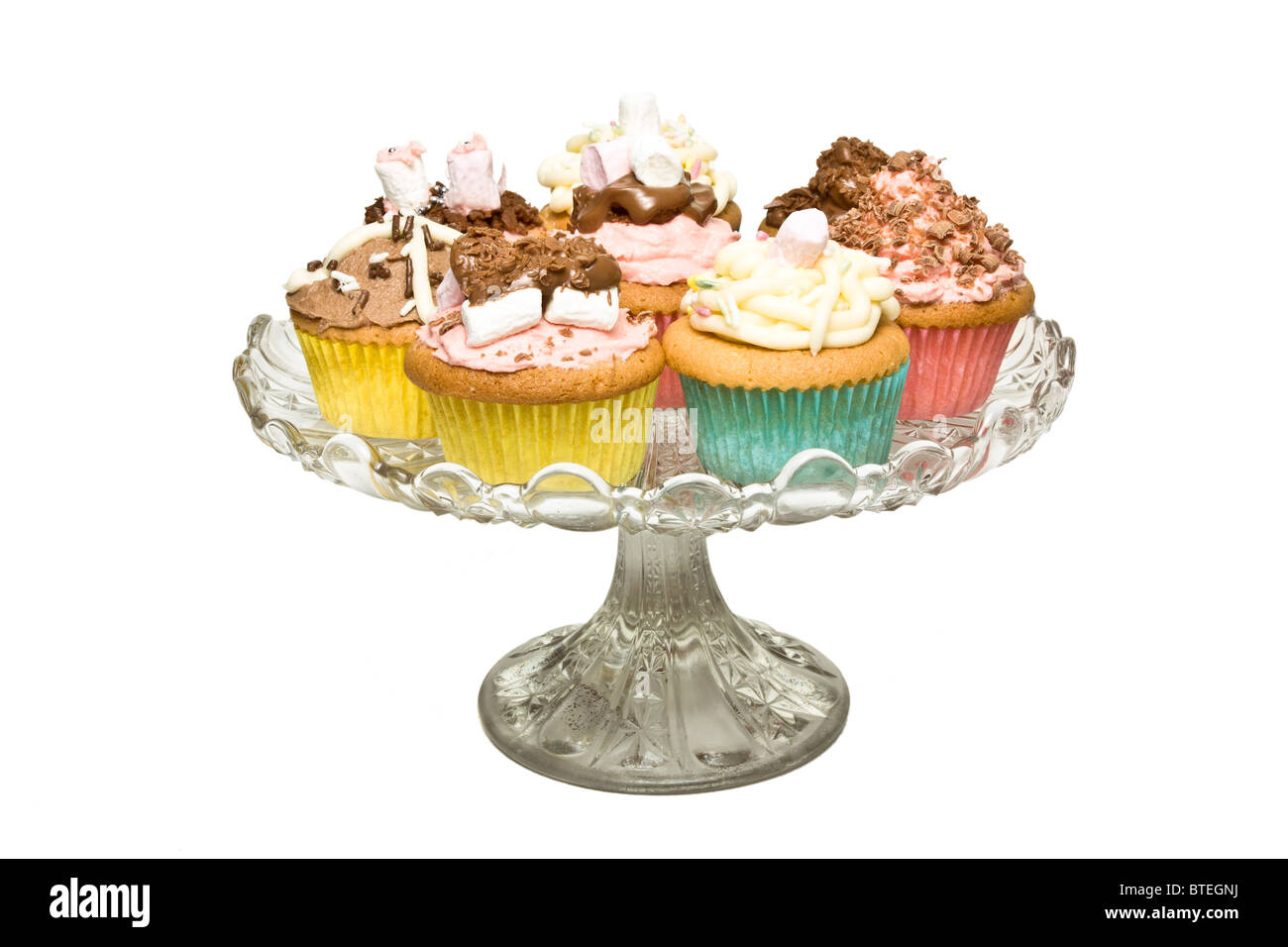 Una selezione di fantasia in casa tortina sul piedistallo di vetro cake stand. Foto Stock