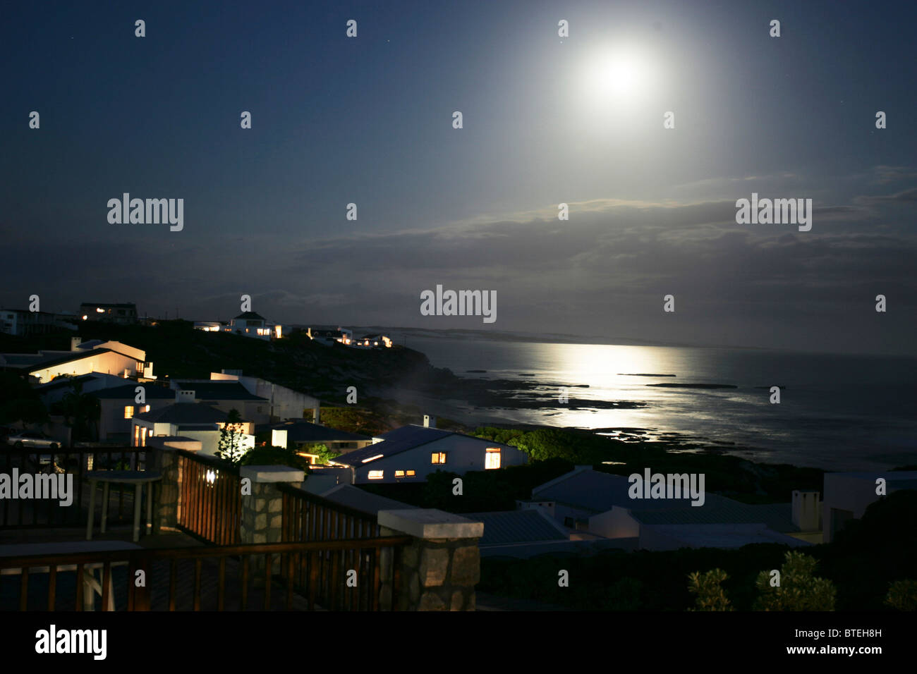 Case del Borgo di Arniston di notte con la luna di riflettere in mare Foto Stock