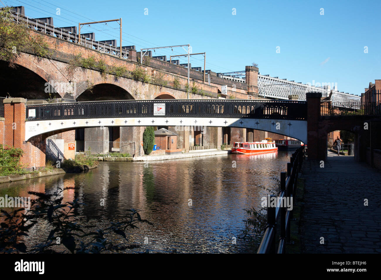 A piedi ponte con tram e alla stazione viadotto sopra Bridgewater Canal in Castlefield Manchester REGNO UNITO Foto Stock