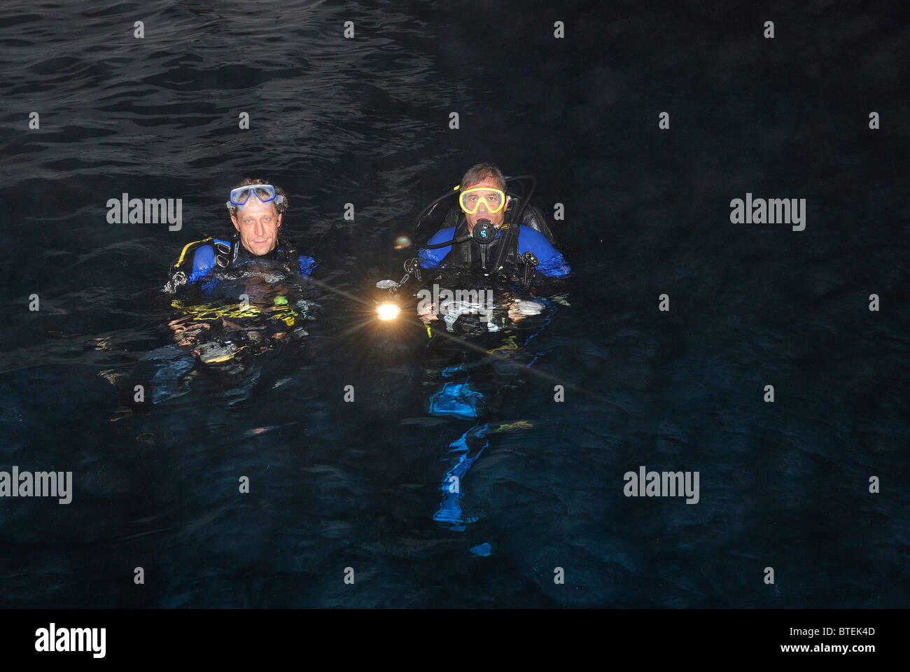 Due subacquei prima di una immersione notturna off Hamata costa, Egitto, Mar Rosso Foto Stock