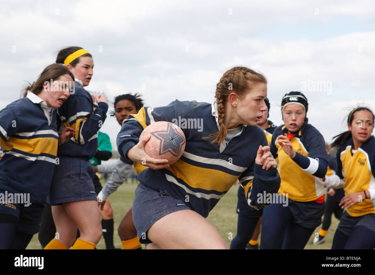 Un George Washington University il giocatore porta la palla contro Navy durante una donna partita di rugby. Foto Stock