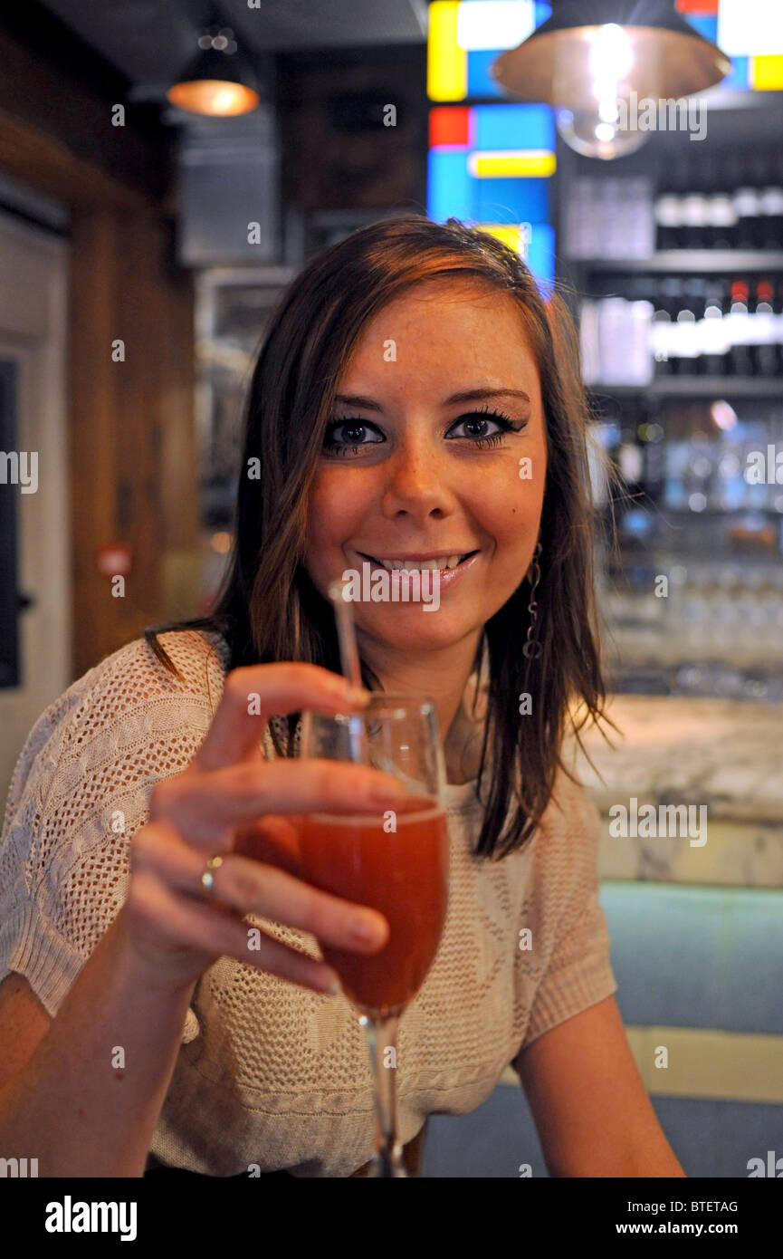 Giovane donna di fragole bere champagne cocktail drink osservando la fotocamera Foto Stock