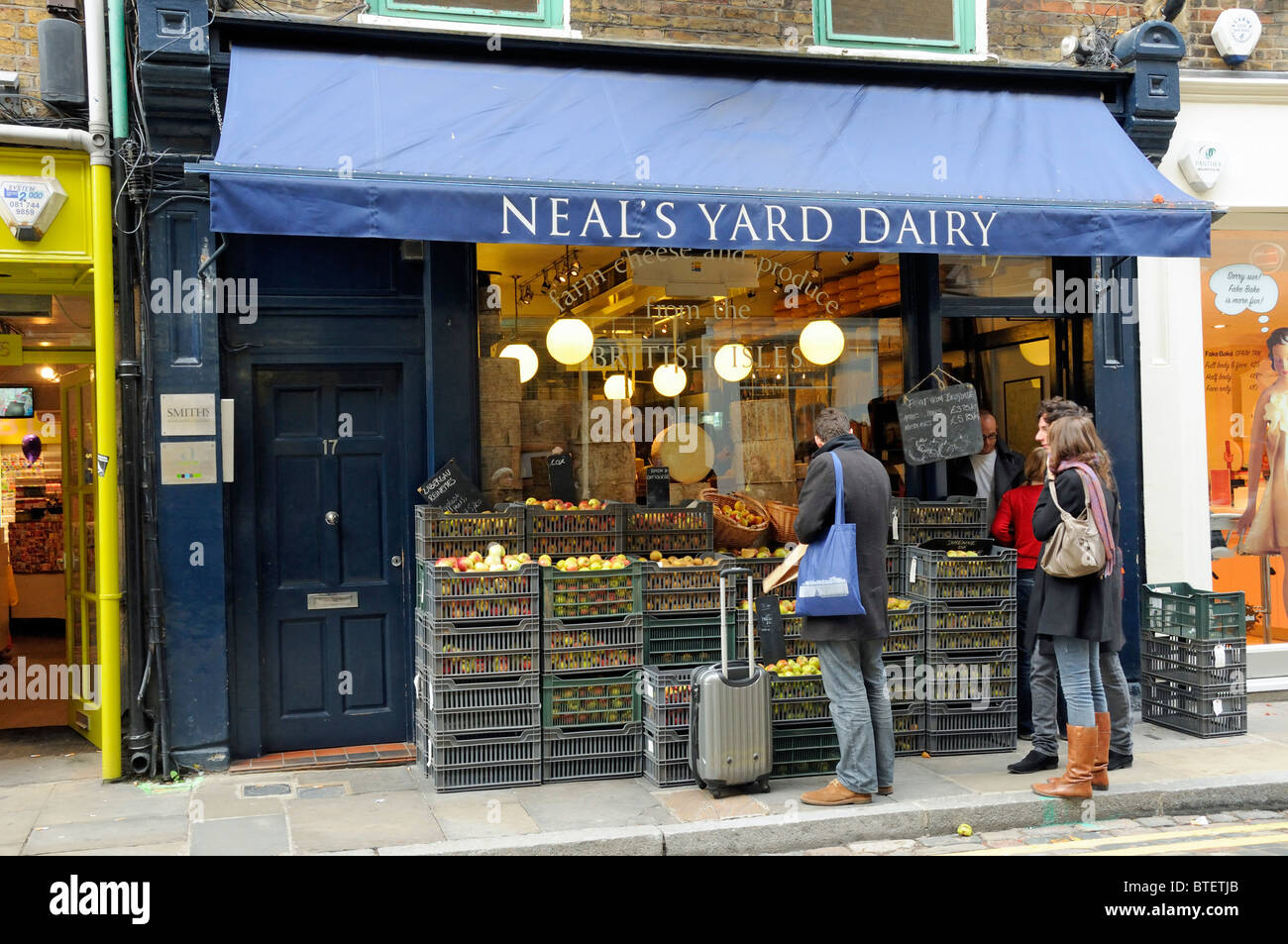 Neal's Yard Dairy con persone che guardano le mele visualizzati al di fuori, Covent Garden Londra Inghilterra Gran Bretagna REGNO UNITO Foto Stock