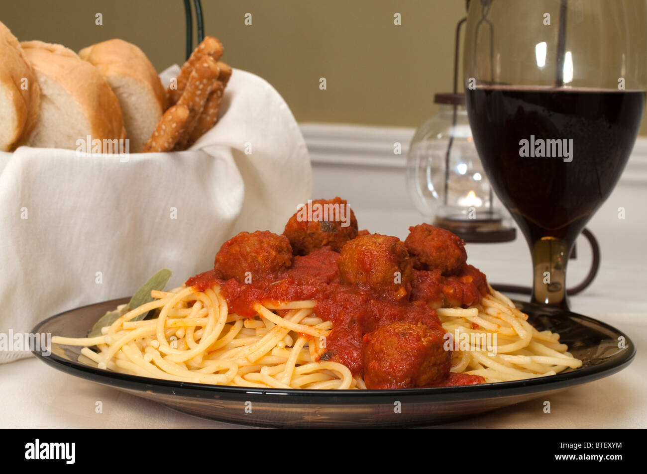 Spaghetti e polpette di carne cena con vino rosso, aglio pane e grissini. Foto Stock