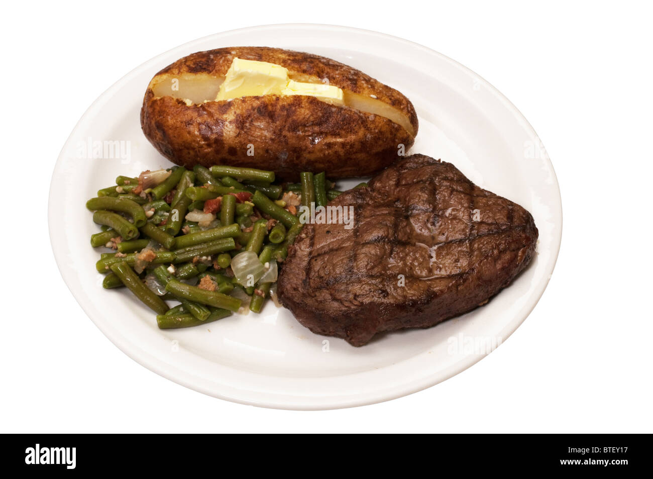 Bistecca di controfiletto con patate al forno e fagioli verdi isolati su sfondo bianco con percorso di clipping. Foto Stock