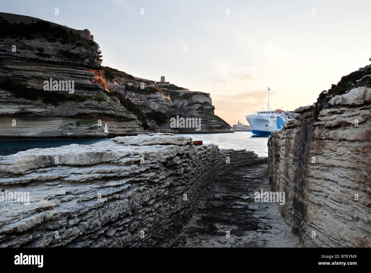 Traghetto entra nel canale di Bonifacio, vista da un drammatico percorso di calcare. Utilizzando la tecnica HDR. Foto Stock