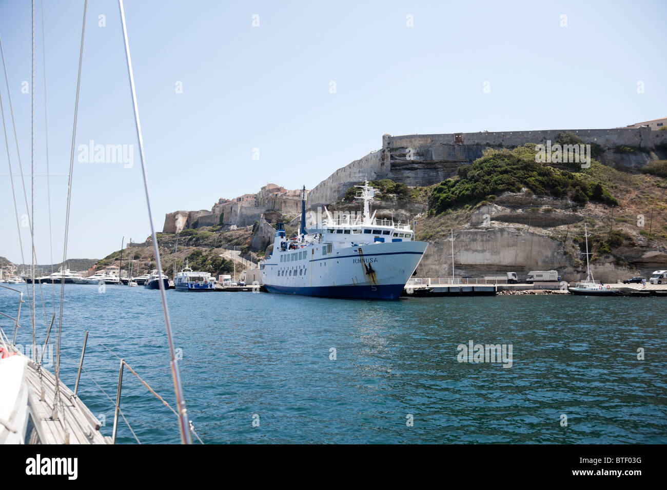La vista interna del porto di Bonifacio con un traghetto da una barca a vela. Foto Stock