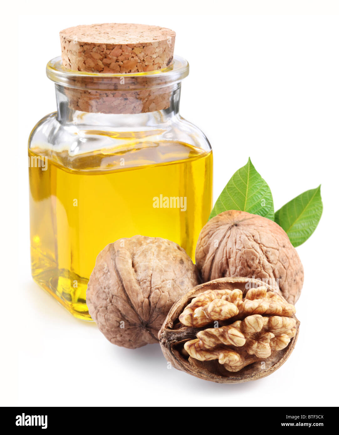 Olio di noce e i dadi su sfondo bianco. Foto Stock