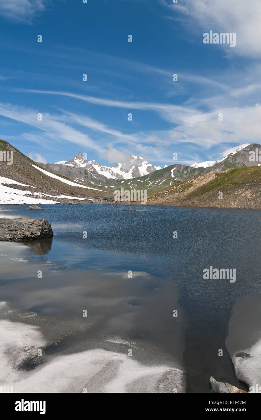 Piccolo lago in Pointe Rousse pass, Valle d'Aosta, Italia con il massiccio del Monte Bianco su sfondo Foto Stock