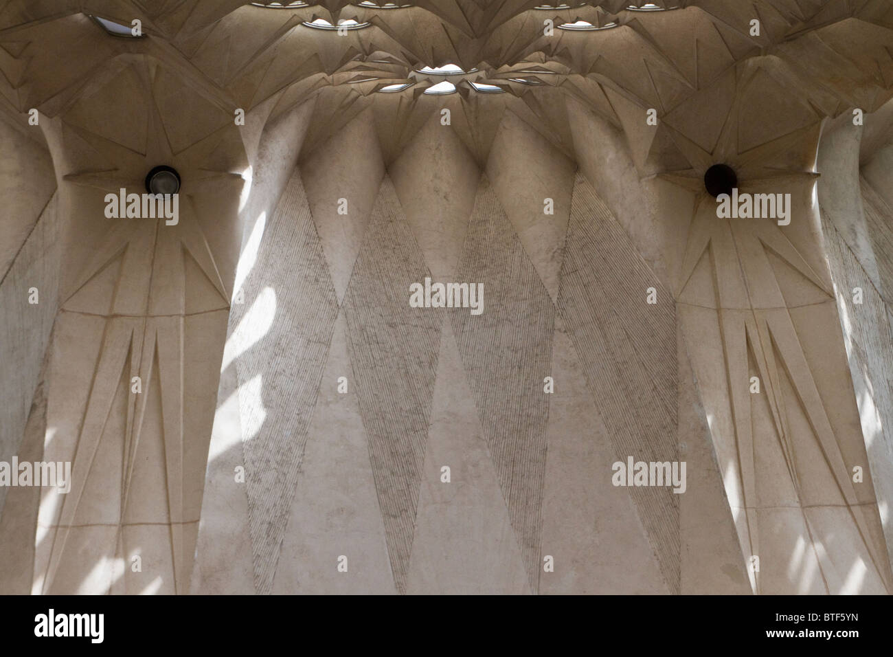 Luce e ombra sui muri in pietra all'interno della cattedrale Sagrada Familia di Gaudi Foto Stock