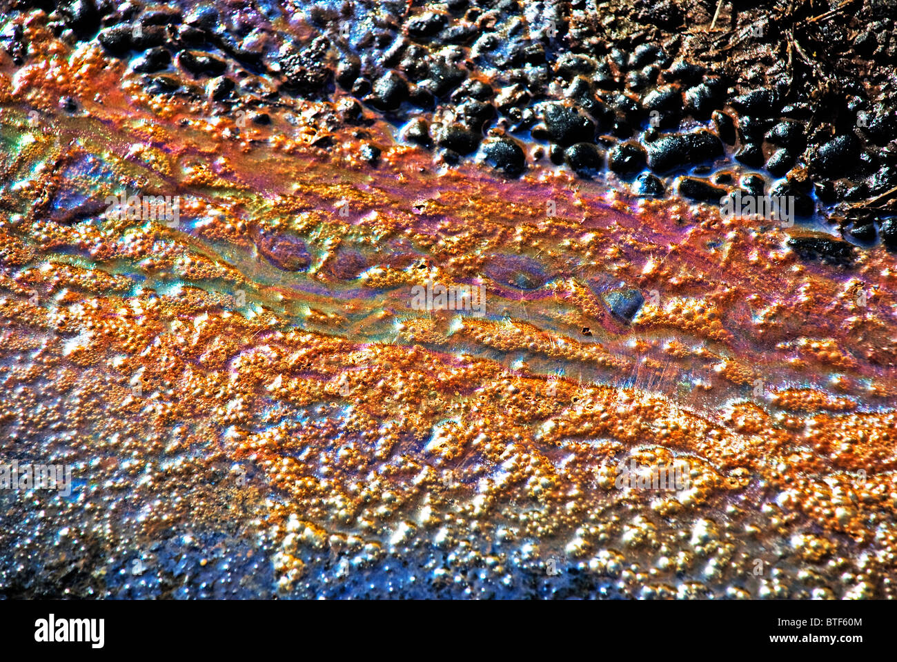 In prossimità della superficie oleosa rainbows da inquinanti schiumatura oleoso e runoff di acqua Foto Stock