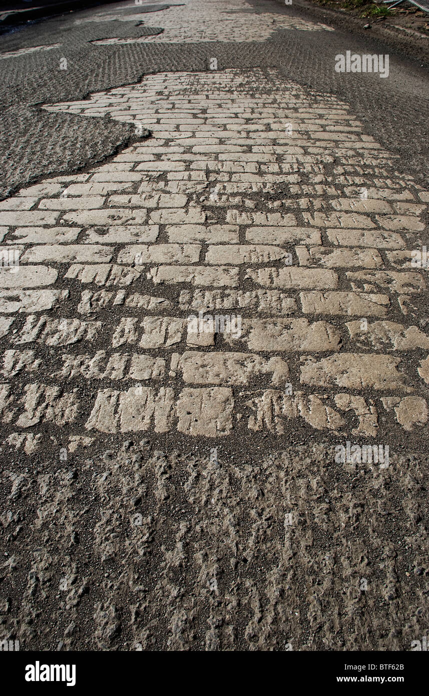 Esposti antica pietra lastricatori in strada in attesa di resurfacing Foto Stock