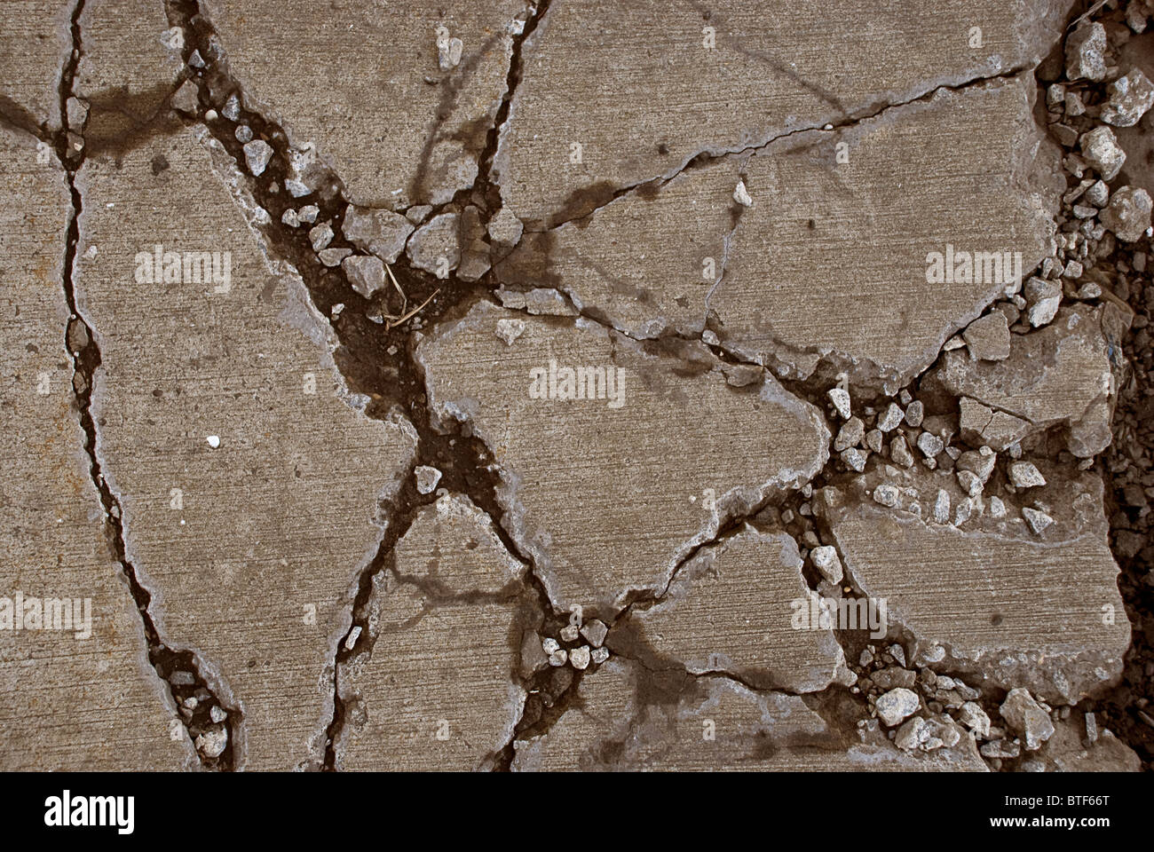 Rotto il marciapiede in calcestruzzo causate da apparecchiature pesanti la guida su di esso Foto Stock