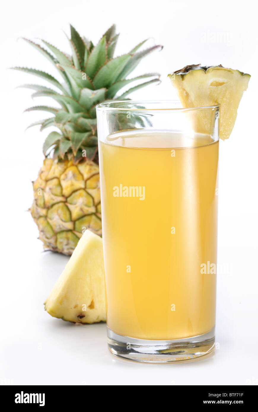 Bicchiere pieno di ananas fresco e succo di ananas frutta sul retro. Foto Stock
