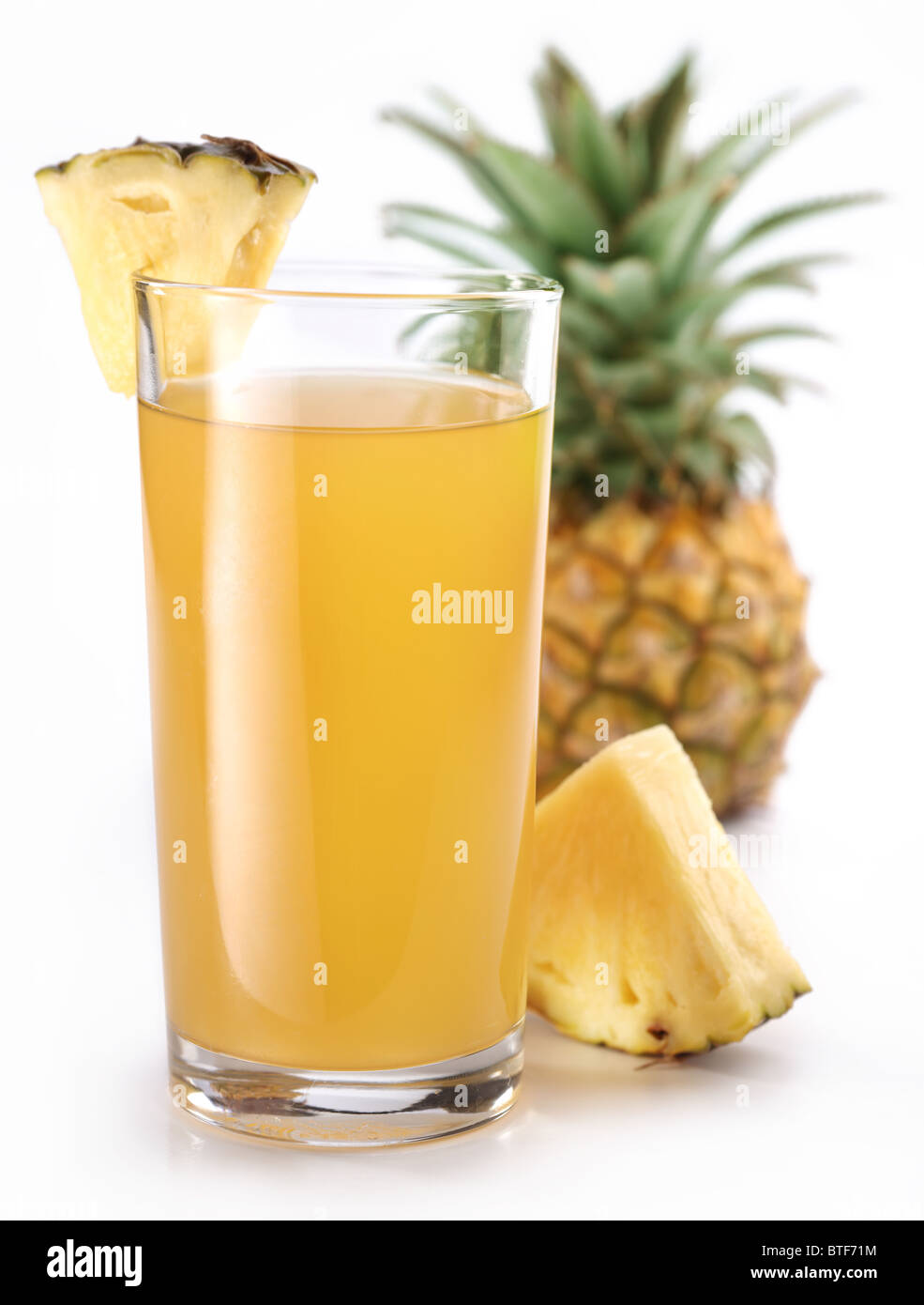 Bicchiere pieno di ananas fresco e succo di ananas frutta sul retro. Foto Stock