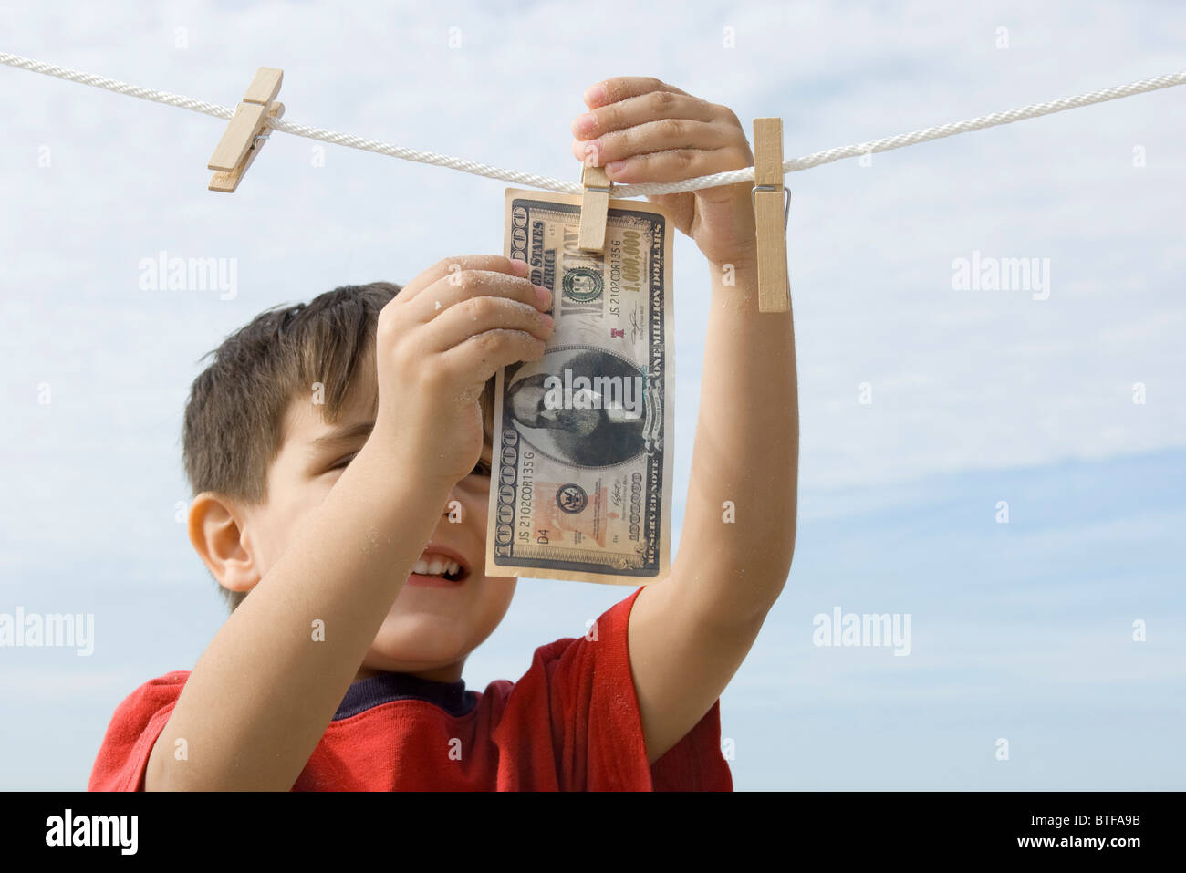 Ragazzo appeso un milione di dollari su vestiti-line Foto Stock