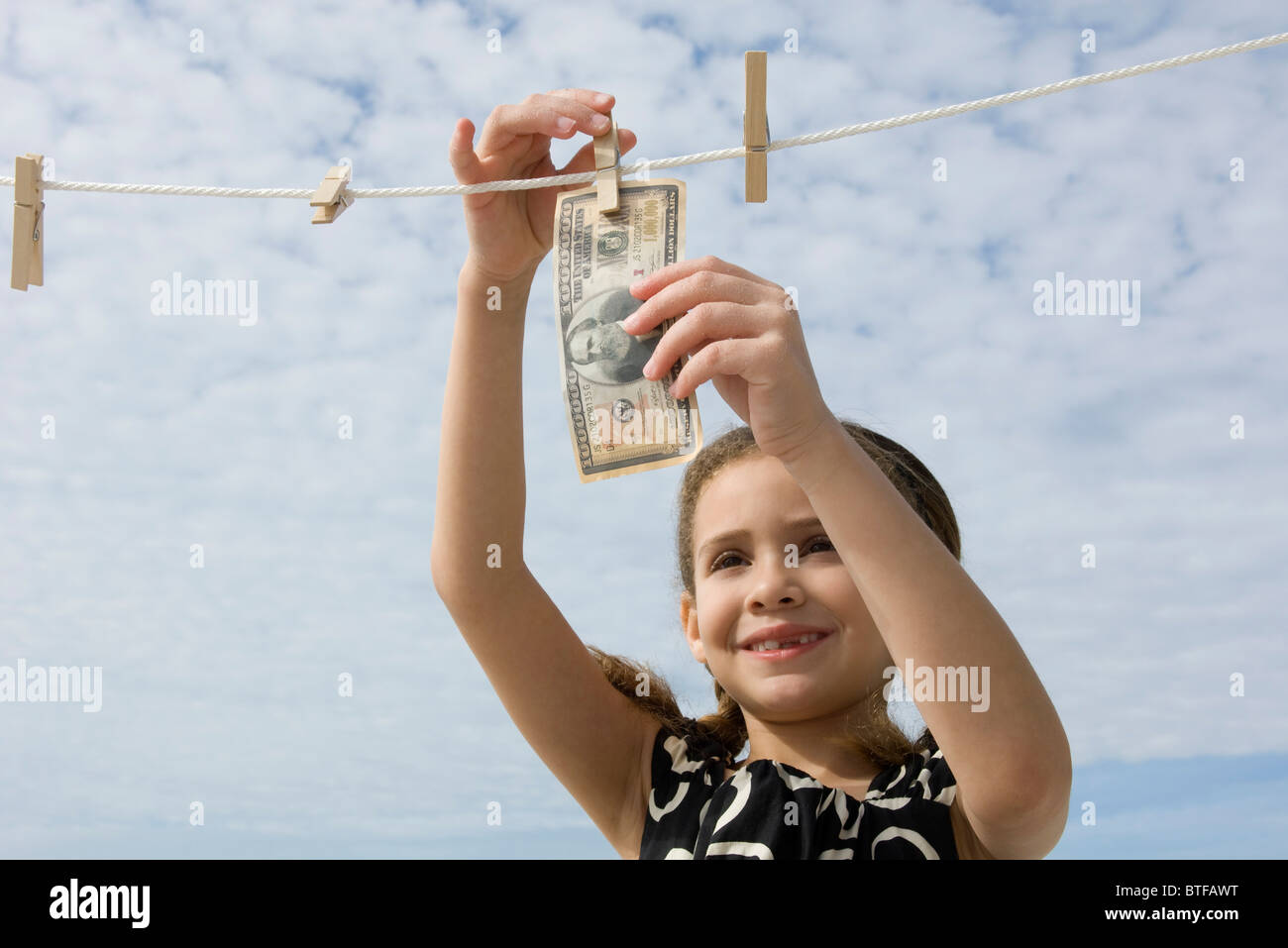 Ragazza appendere un milione di dollari su vestiti-line Foto Stock