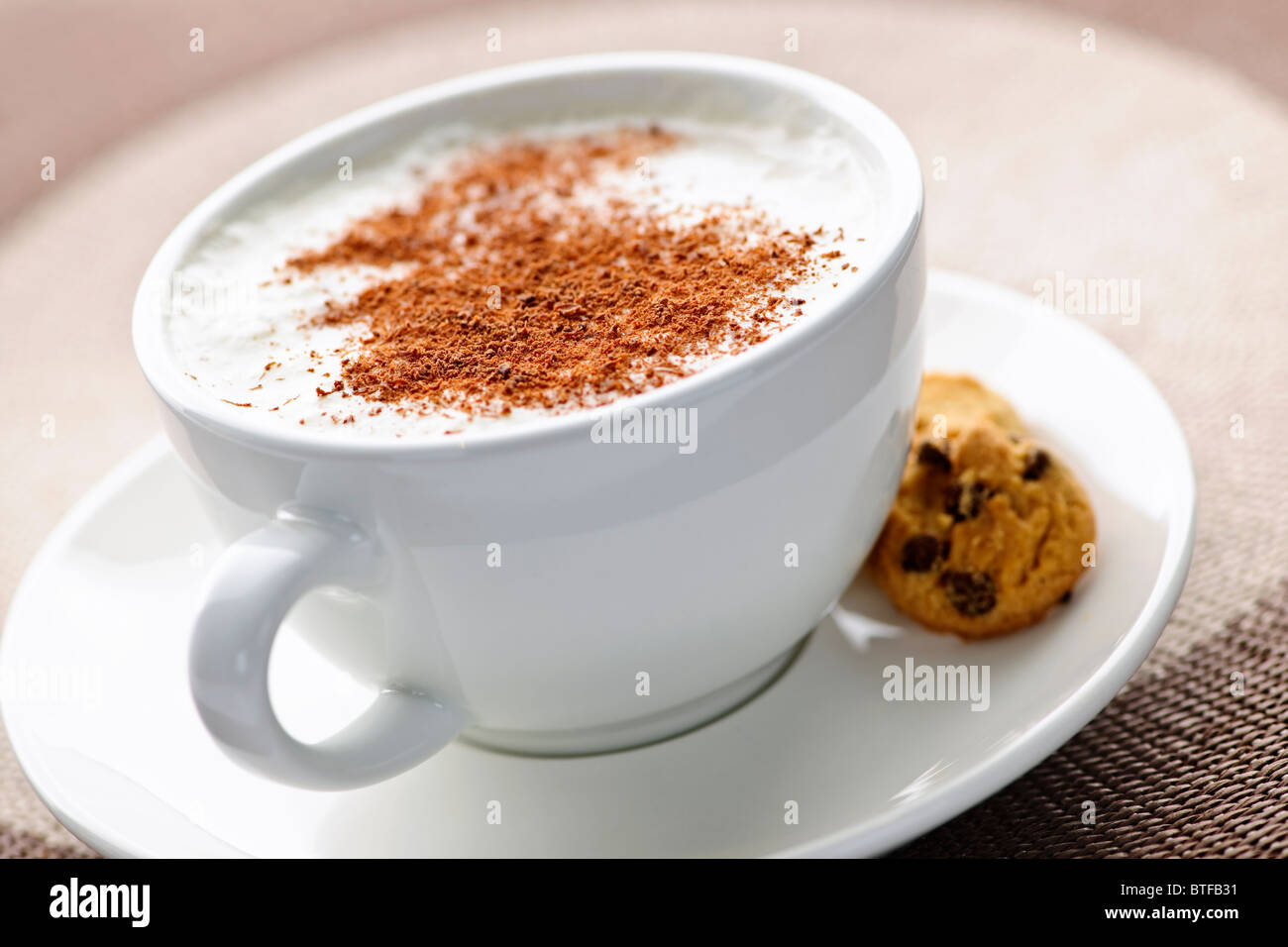 Cappuccino o latte caffè nella tazza con schiuma di latte e biscotti Foto Stock