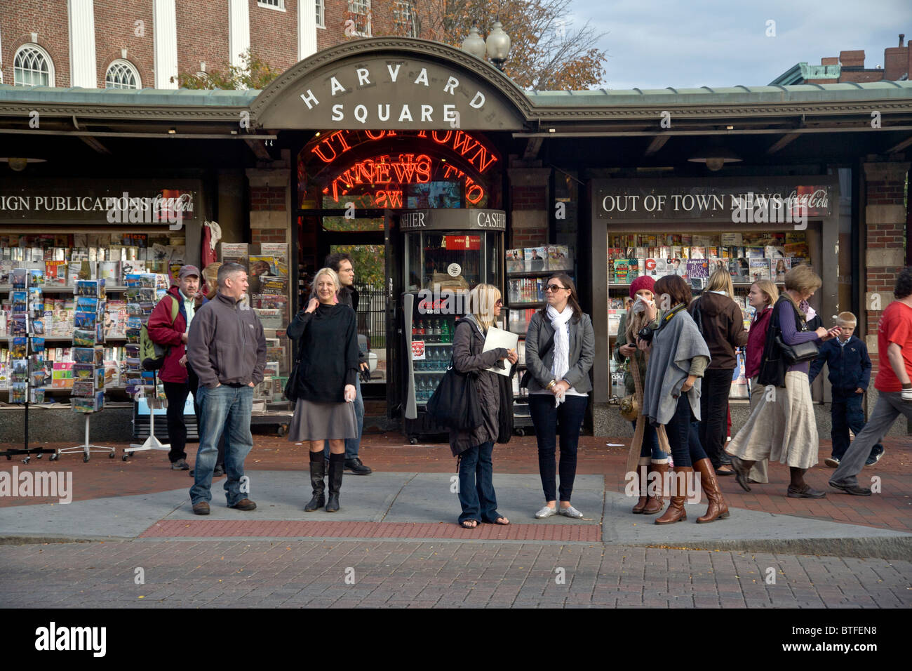 Local pedoni attendere di fronte alla notizia di stand e la stazione della metropolitana di attraversare il Massachusetts Avenue in Harvard Square, Cambridge, Foto Stock