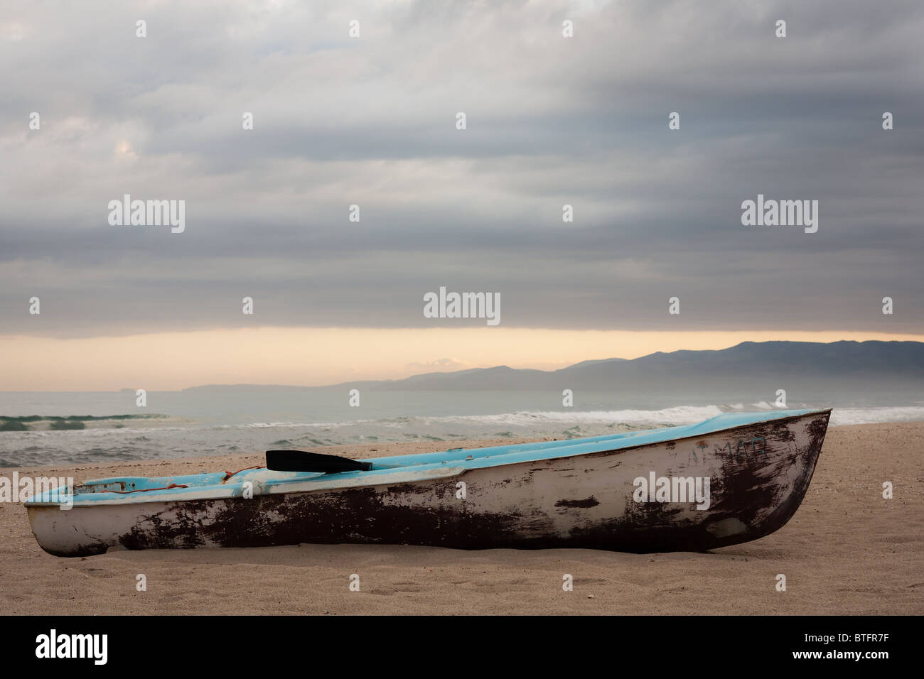 Vecchia barca arrugginito abbandonato sulla spiaggia; nuvoloso alba. Foto Stock