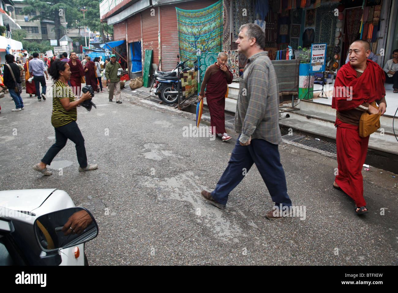 Una vita quotidiana scena di strada con turisti e del popolo tibetano e monaci in McLeod Ganj, India Foto Stock