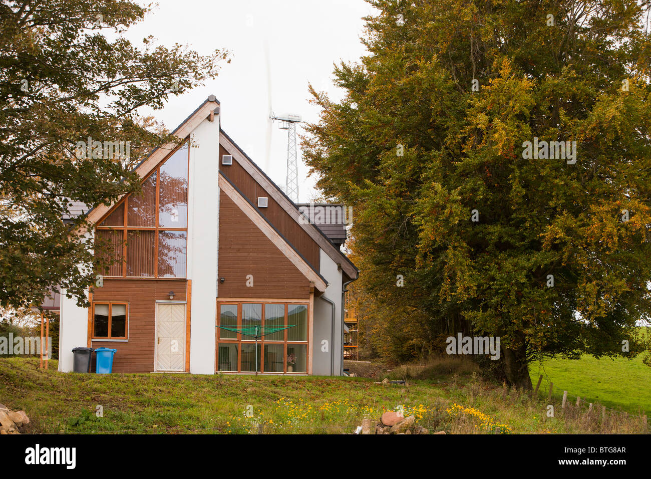 Un architetto progettato eco casa con una turbina eolica che fornisce tutto il fabbisogno di energia elettrica della casa vicino a Lesmahagow, Foto Stock