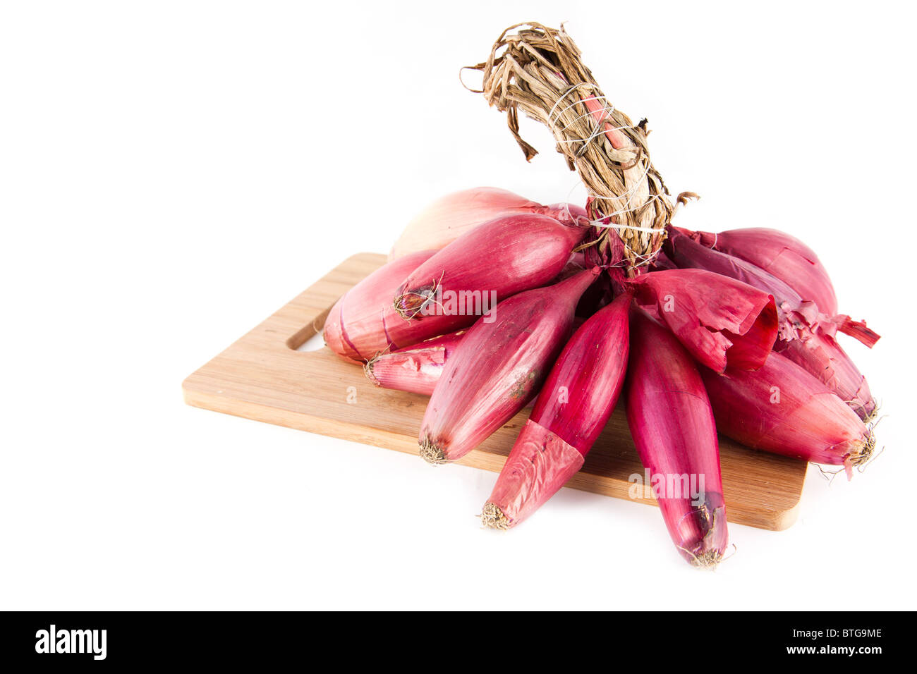 Le cipolle rosse su un tagliere, isolato su sfondo bianco. Foto Stock