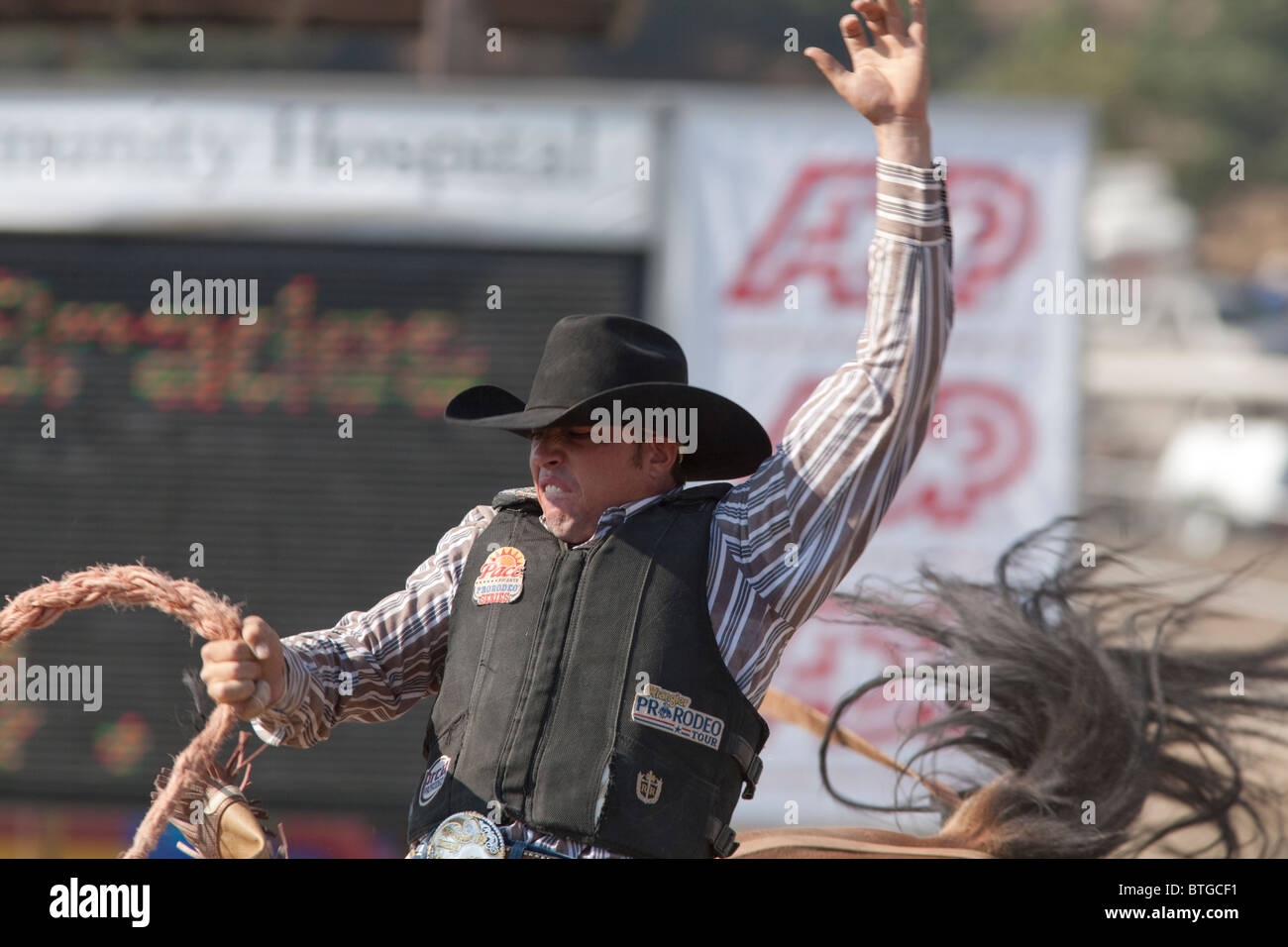 Cowboy Bradee Hughes compete in sella Bronc evento presso il San Dimas Rodeo a San Disma il 2 ottobre 2010. Foto Stock