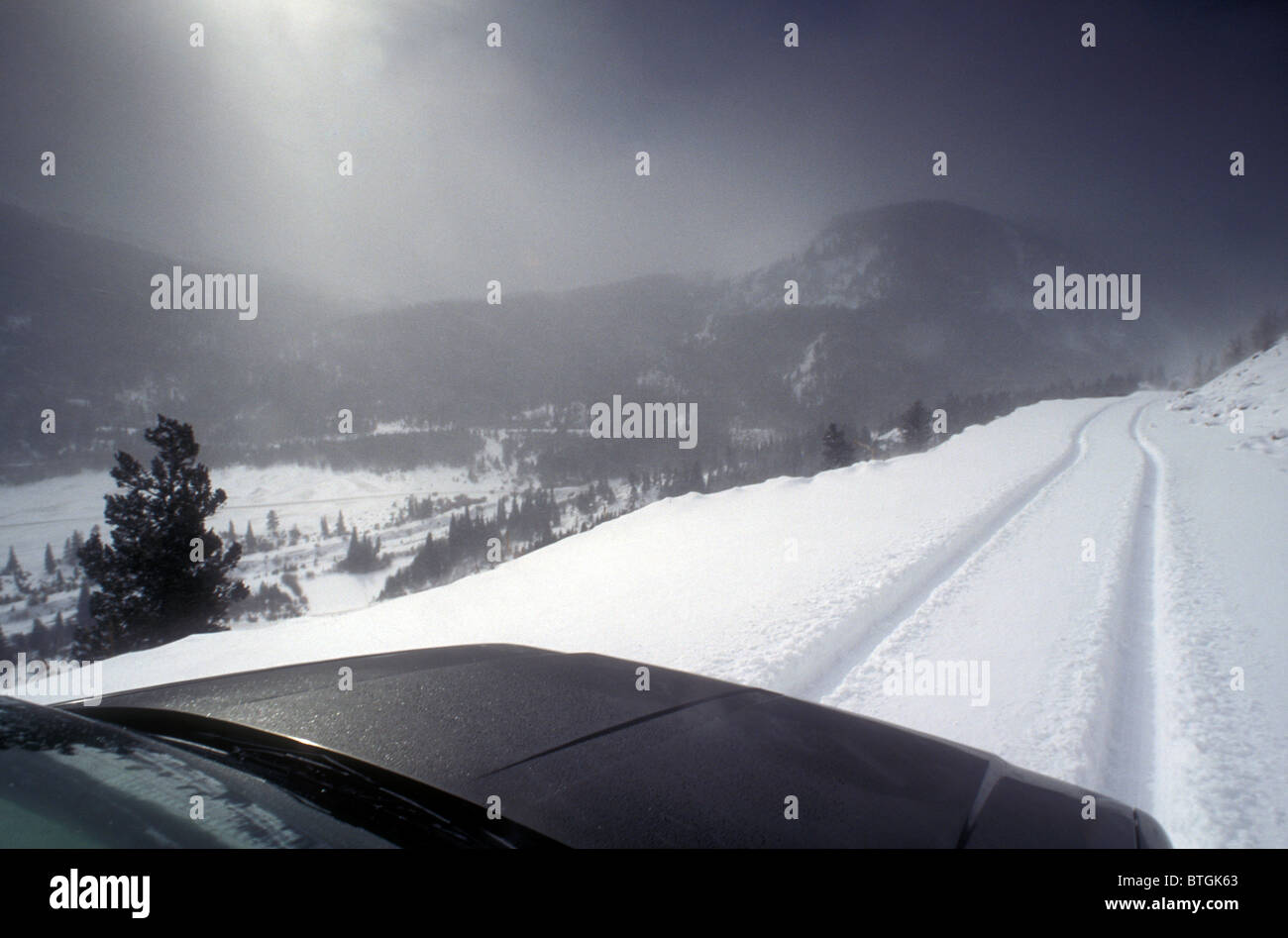 La guida verso il basso coperto di neve road in Colorado negli Stati Uniti. Foto Stock