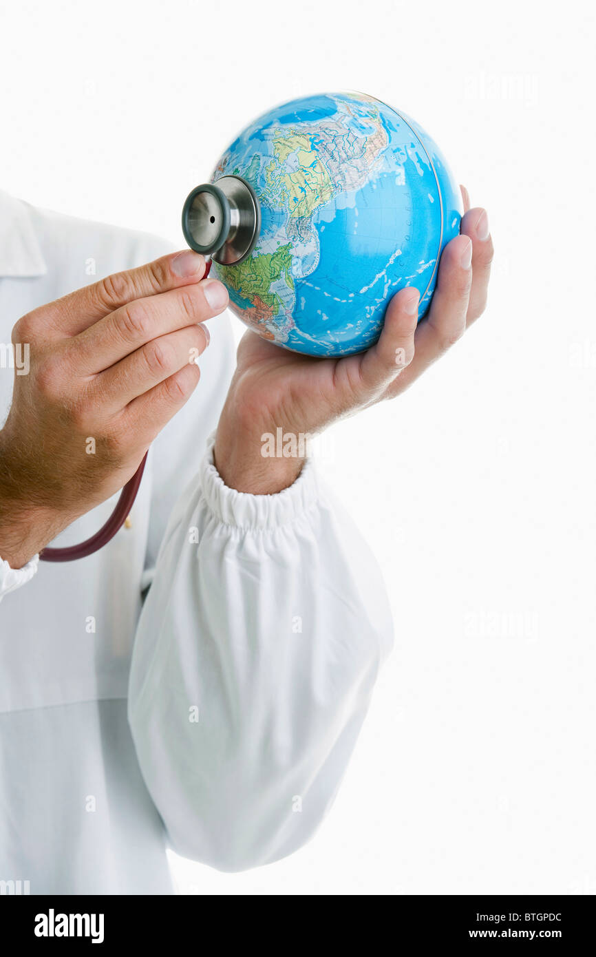 Medico tenendo le mani uno stetoscopio al mondo Foto Stock