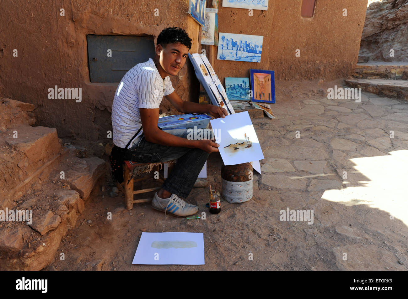 L'uomo vendere dipinti in Ait Benhaddou e la spettacolare città fortificata nel sud del Marocco. Foto Stock
