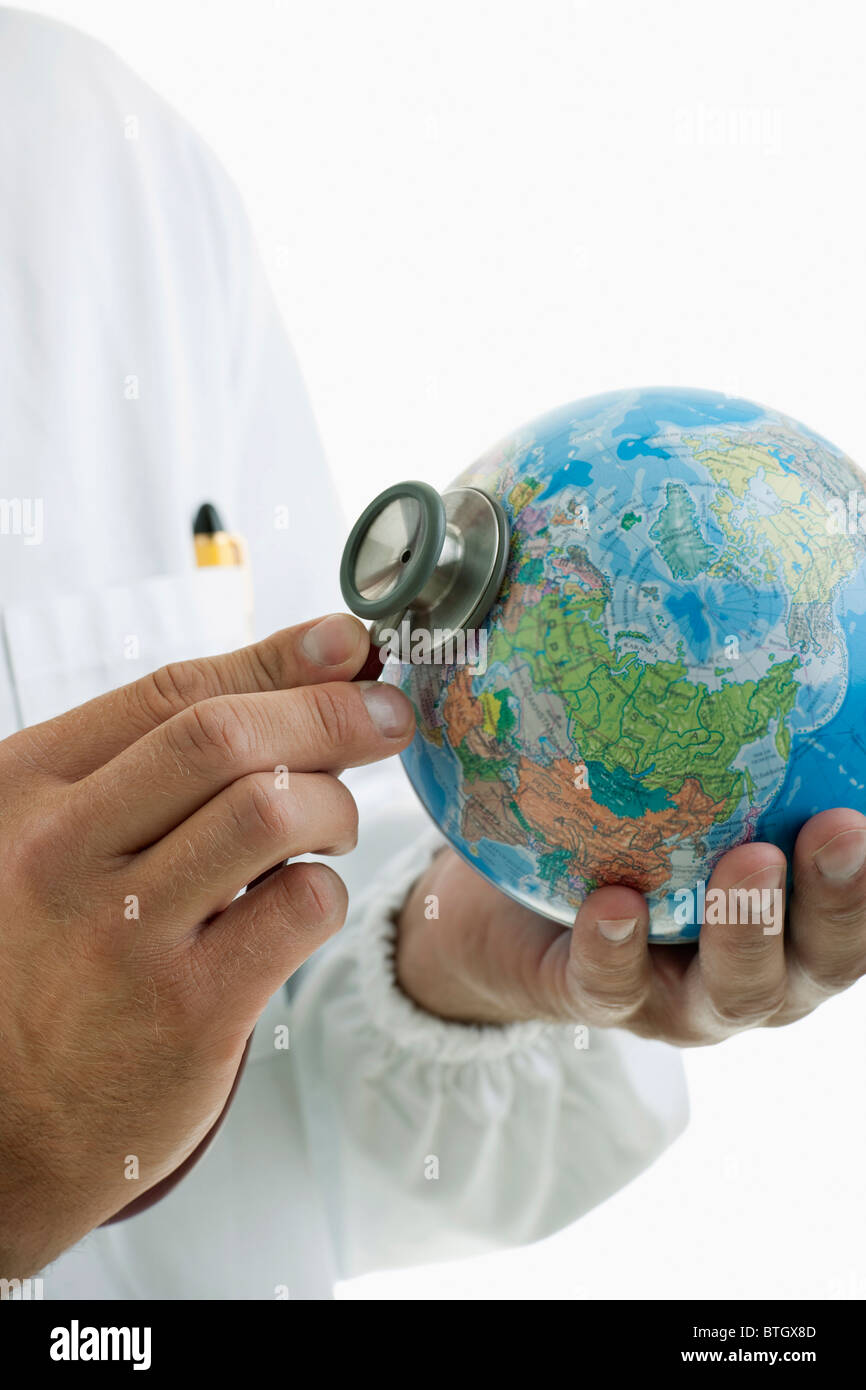 Medico tenendo le mani uno stetoscopio al mondo Foto Stock