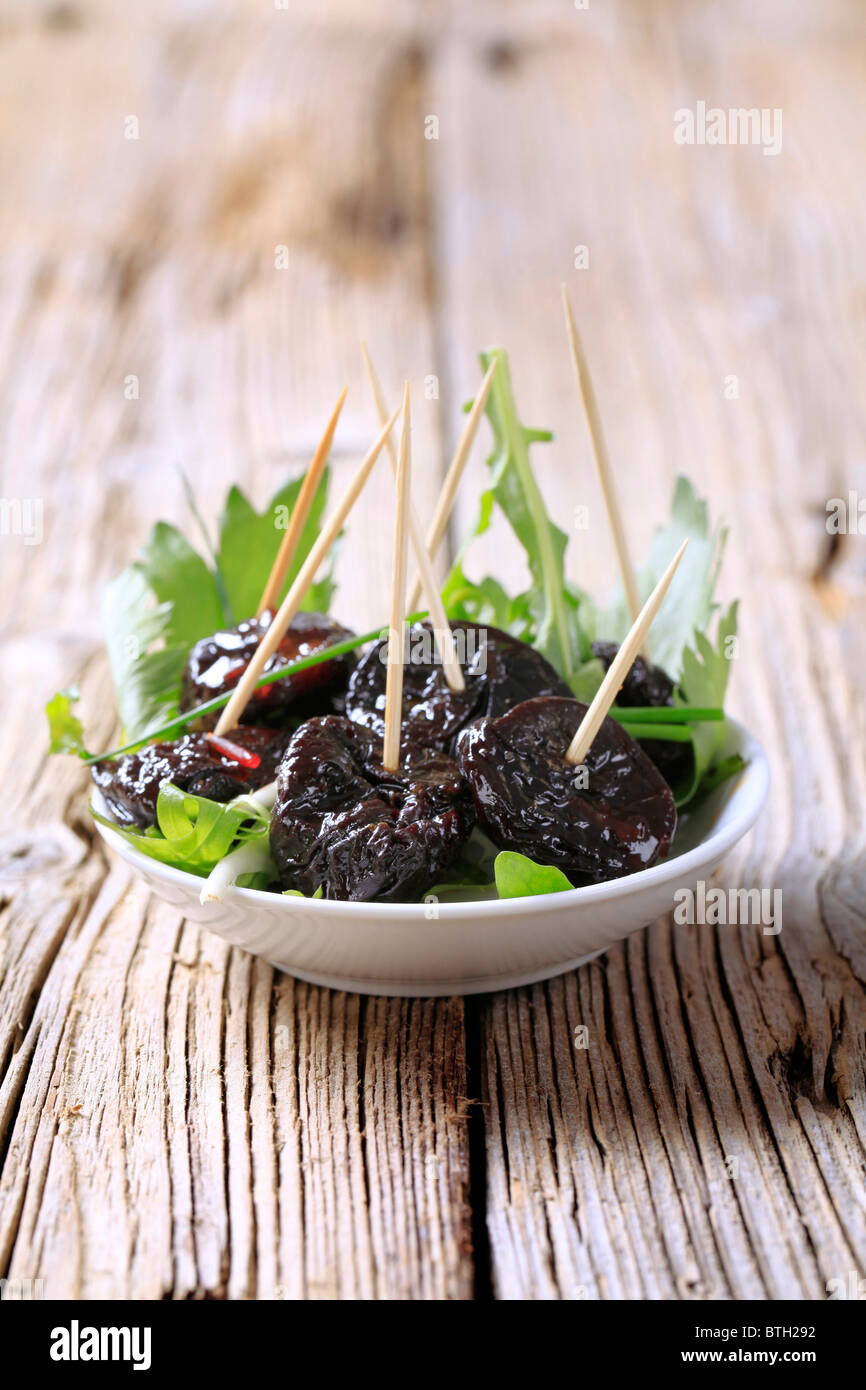 Ciotola di prugne e insalata verde Foto Stock