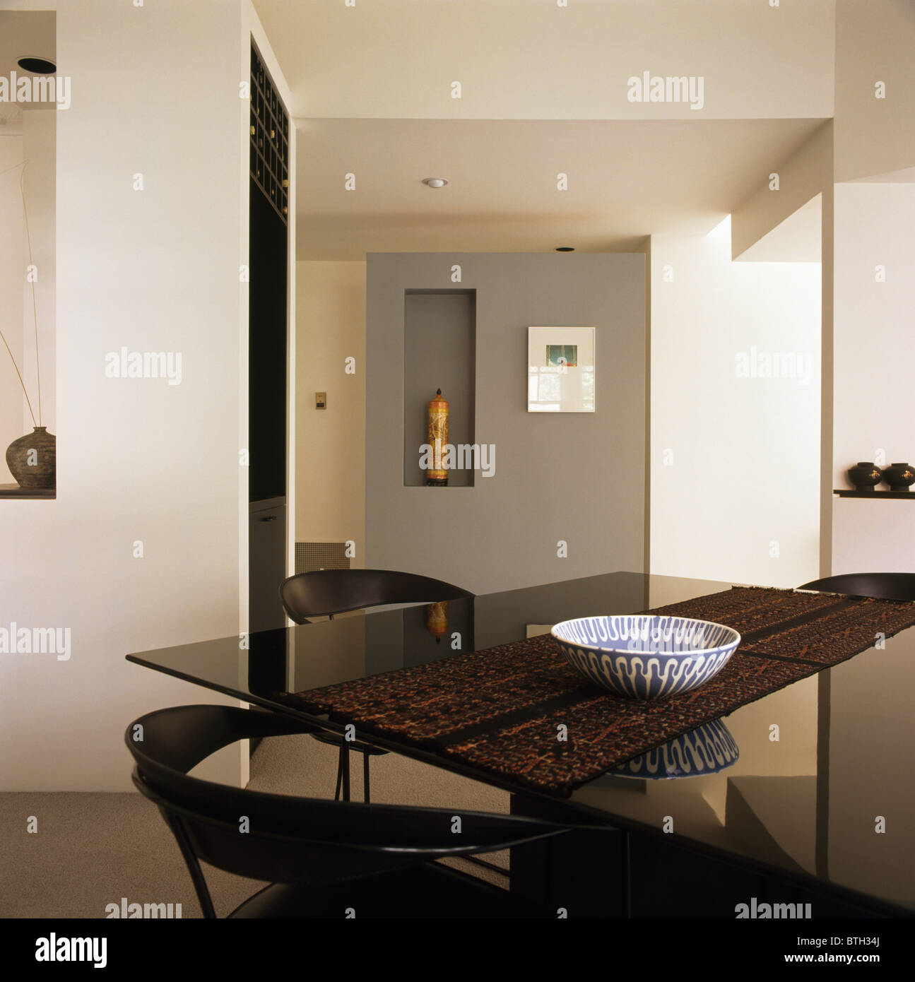 Tessuto runner nero sul tavolo di vetro in bianca e moderna sala da pranzo Foto Stock
