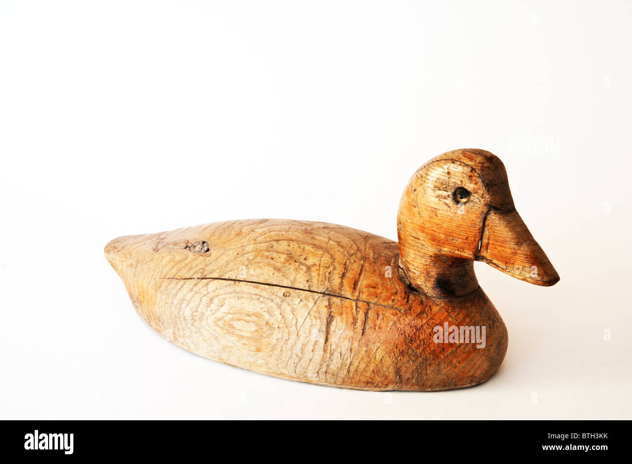 Vintage scolpito a mano e non verniciata anatra esca su uno sfondo bianco. Foto Stock