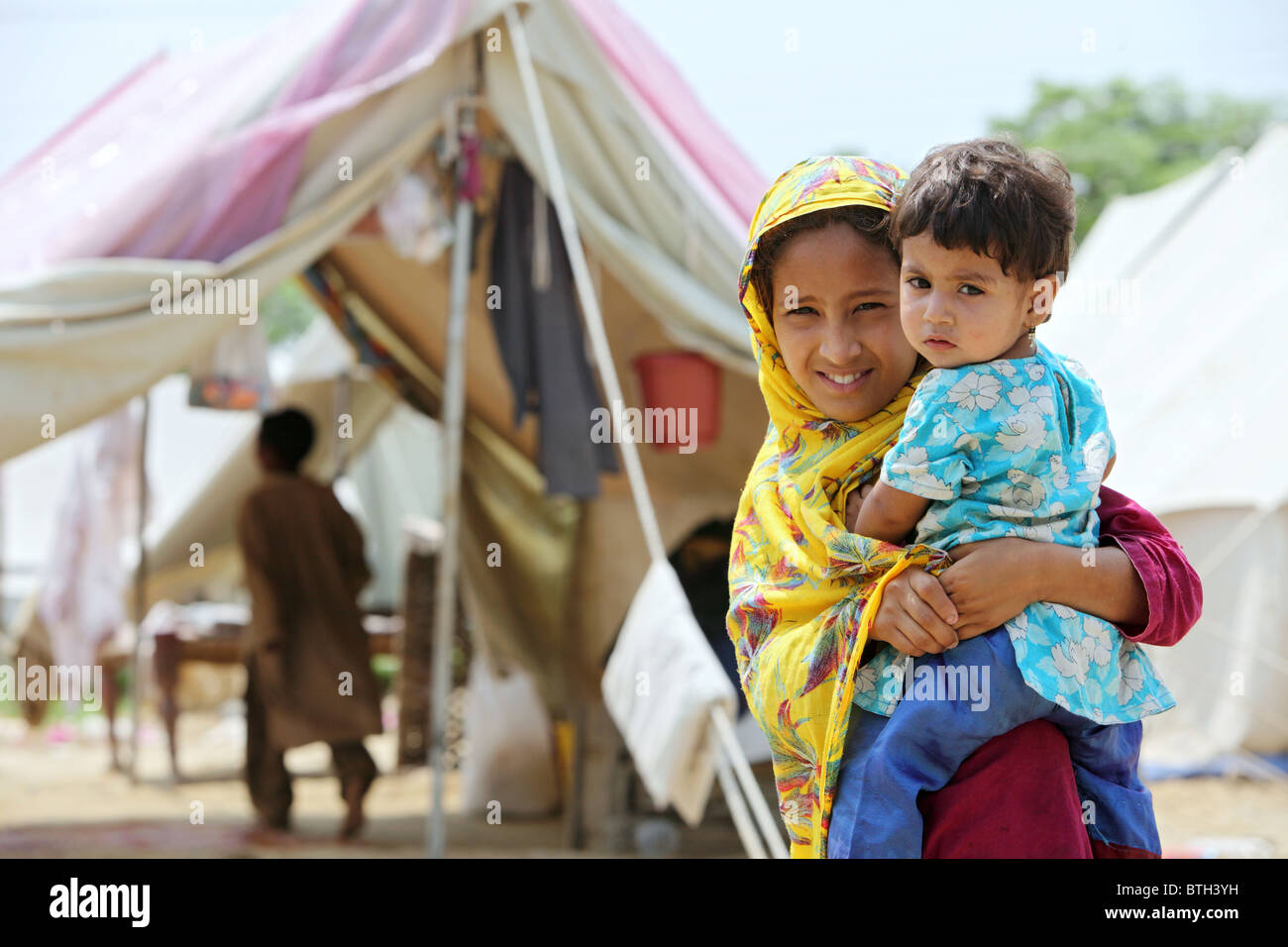 Una madre e un bambino in un campo di rifugiati dopo un disastro, Charsadda, Pakistan Foto Stock