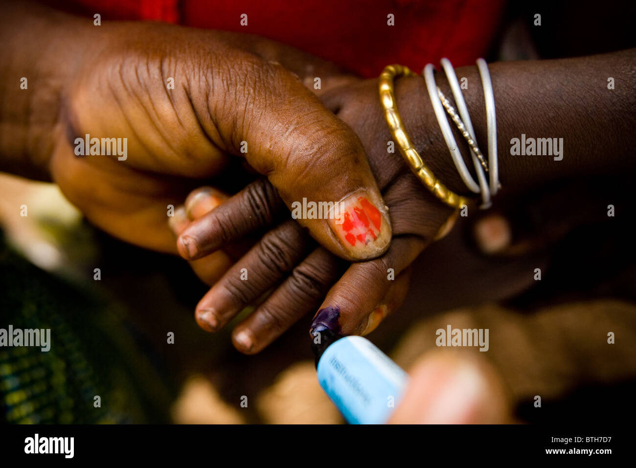 Un volontario della comunità segna il dito di un bambino con inchiostro durante un nazionale di immunizzazione antipolio esercizio Foto Stock