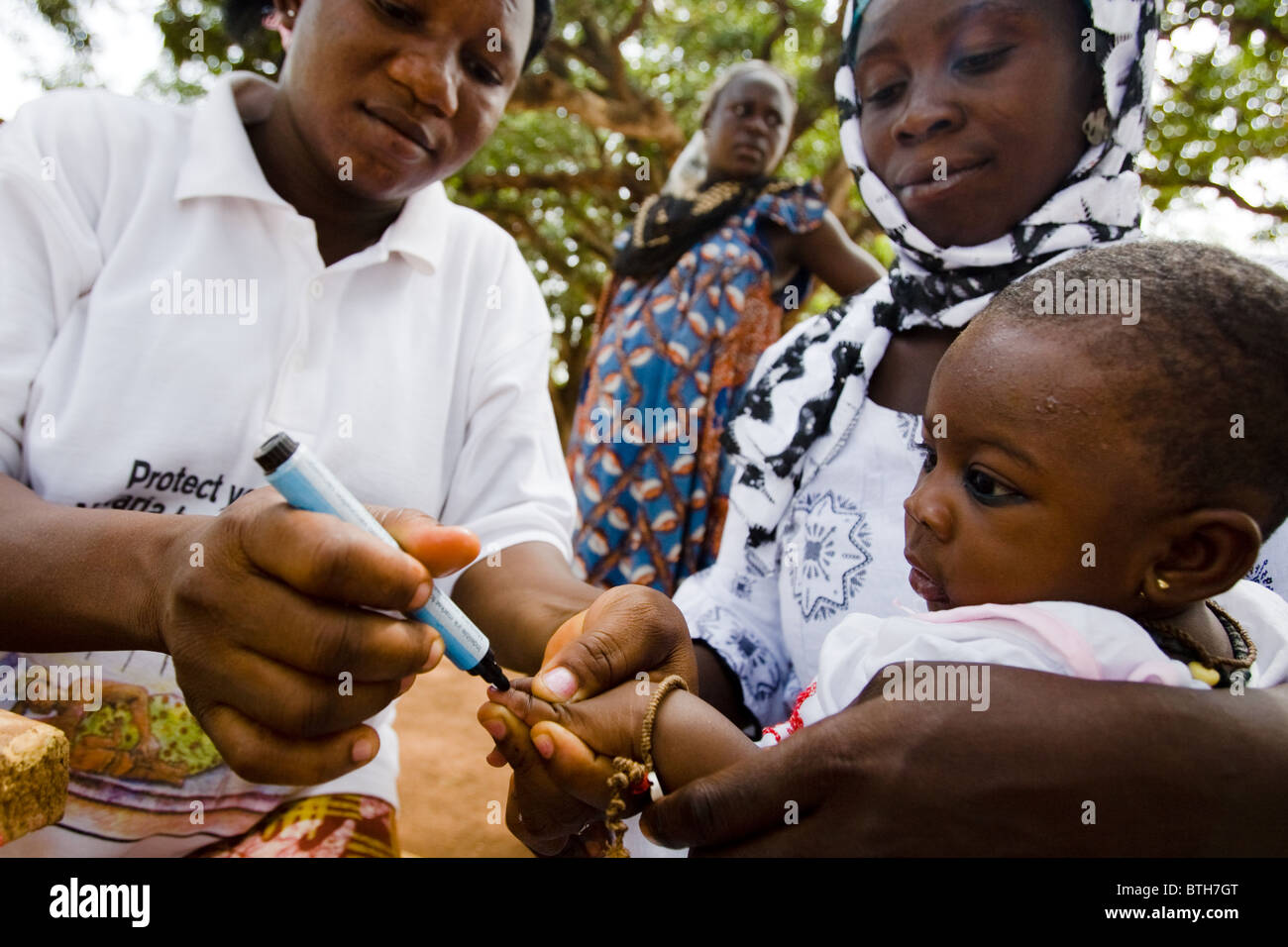 Un operatore sanitario segna il dito di un bambino con inchiostro durante un nazionale di immunizzazione antipolio esercizio Foto Stock