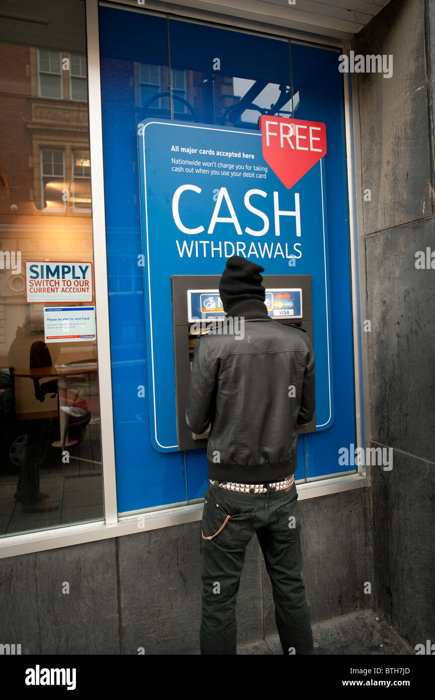 Un uomo di ritirare denaro contante in un Nationwide Building Society ATM Foto Stock