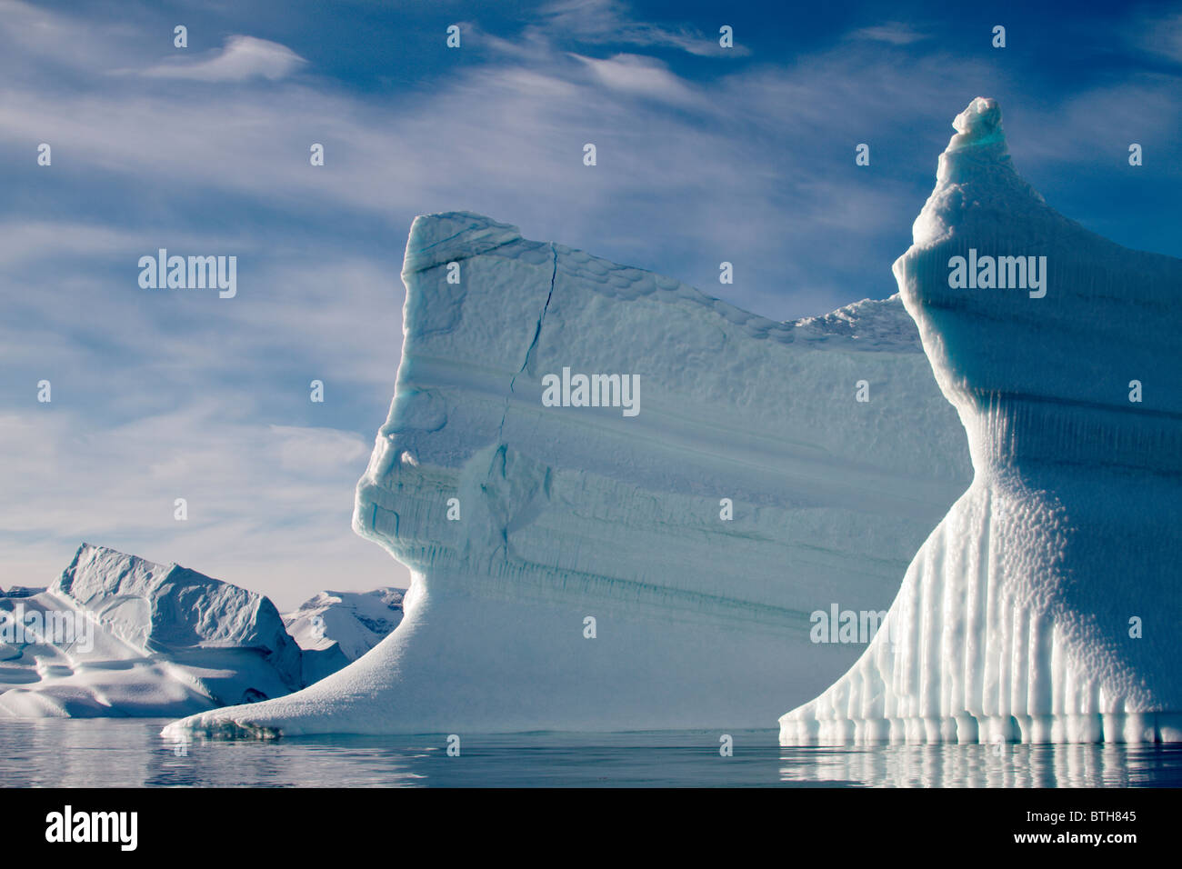 Due iceberg assomigliano icebreakers galleggiante attraverso la calma i cieli blu della Groenlandia artico Foto Stock