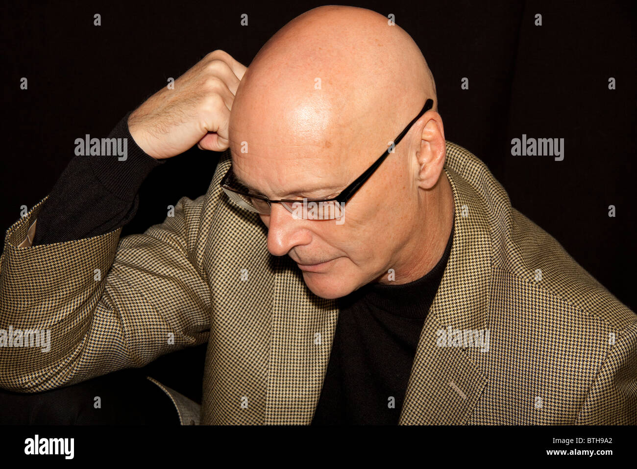 Grave, uomo calvo con testa in mani indossando occhiali da vista Foto stock  - Alamy