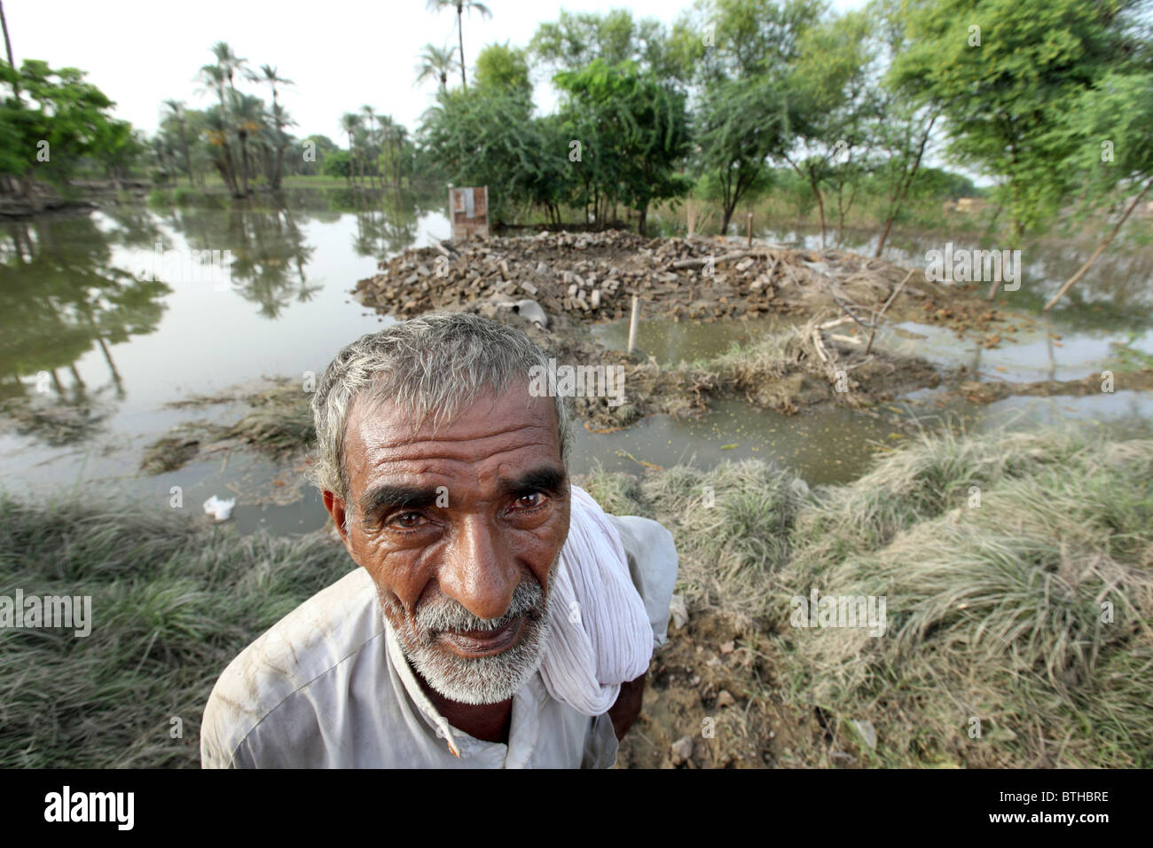 Un vecchio uomo in piedi davanti ai resti della sua casa spazzati via da un alluvione, Bahrdi, Pakistan Foto Stock