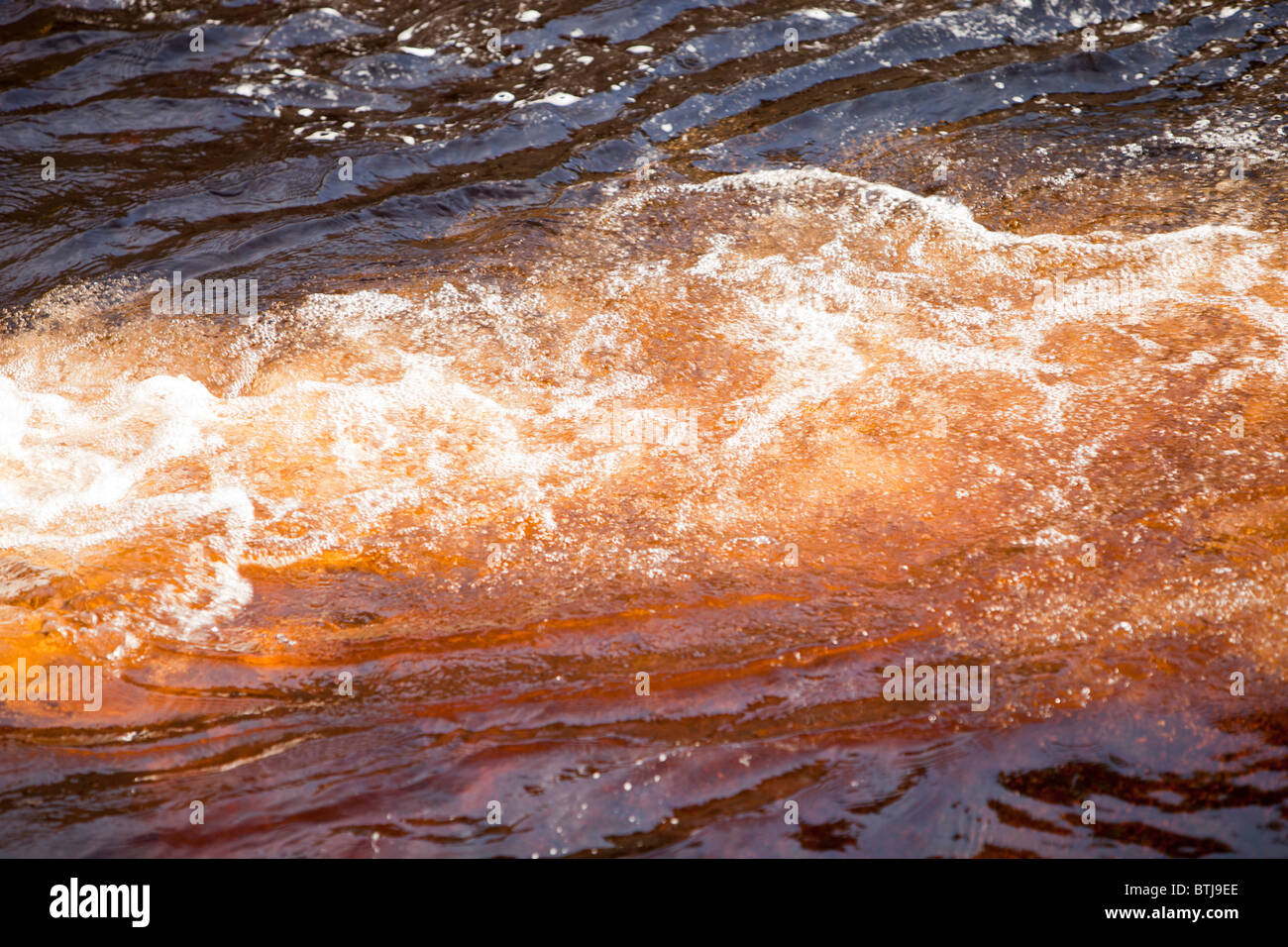 Bolle di ossigeno nella torba colorate acqua nel fiume Dunsop, Trogolo di Bowland, Lancashire, Regno Unito. Foto Stock