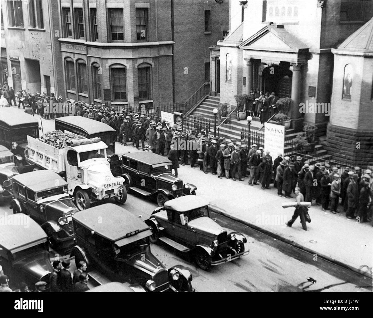 Depressione- disoccupati uomini schierati nella parte anteriore della Chiesa di San Francesco d Assisi in attesa di ricevere un nichel ciascuno da Padre Gabriel. Foto Stock