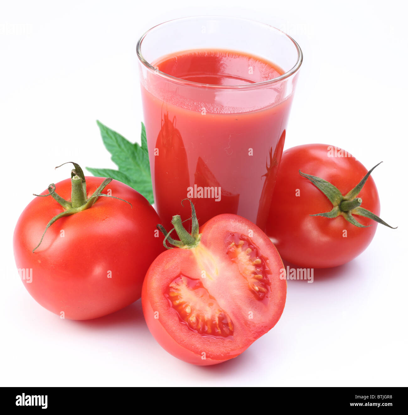 Bicchiere pieno di pomodoro fresco e succo di pomodori sono intorno al bicchiere. Foto Stock