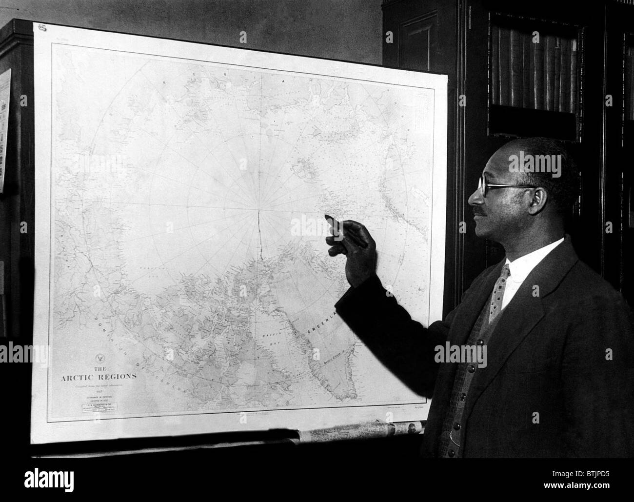 Explorer Matt Henson, che co-scoperto il Polo Nord, Guarda a una mappa della regione artica. New York, New York, 1926. La cortesia C Foto Stock