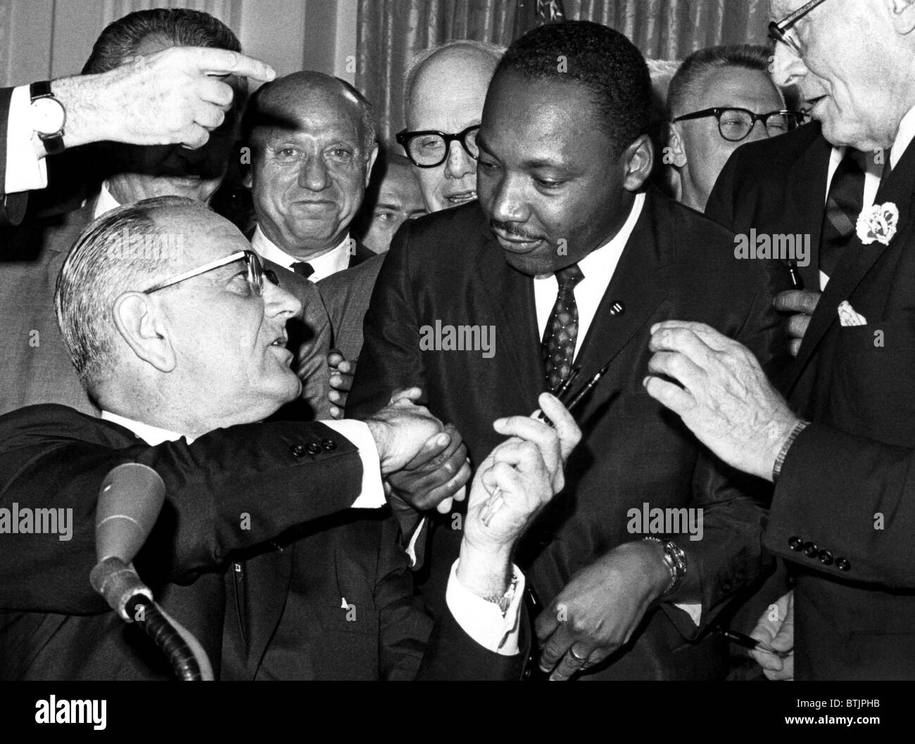 Bancata anteriore: presidente Lyndon Johnson consegnando una penna di Martin Luther King Jr., durante la cerimonia per la firma del settore civile Foto Stock