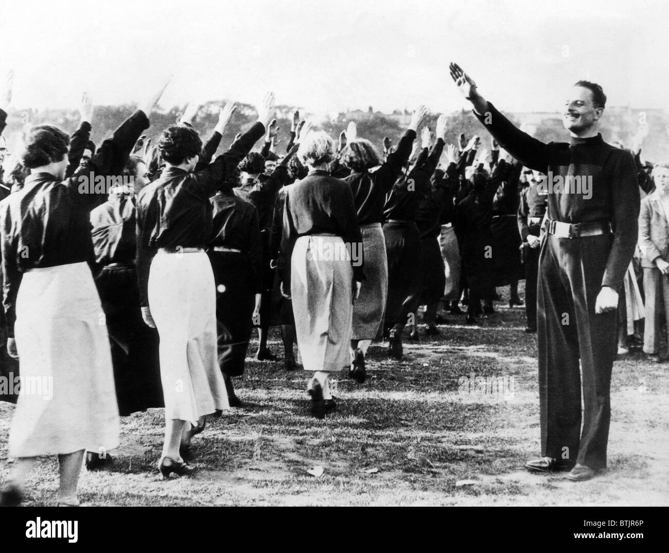 Sir Oswald Mosley, leader dell'Unione Britannica dei Fascisti, prendendo un salue fromt egli womean membri del partito un sthey arrivati Foto Stock